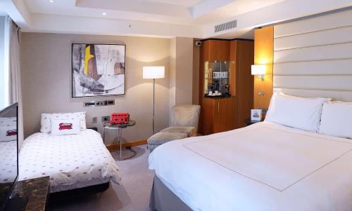 um quarto de hotel com uma cama e uma cadeira em Conrad London St James em Londres