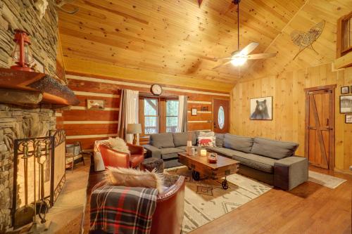 a living room filled with furniture and a stone fireplace at Family-Friendly Blue Ridge Cabin with Game Room! in Fleetwood