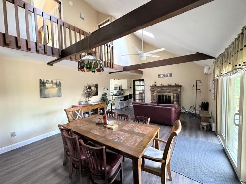a dining room and living room with a table and chairs at WOW!! Ultimate Pocono Retreat, Hot Tub, Game Room, Deck, Lakes, Skiing, Pools in Long Pond