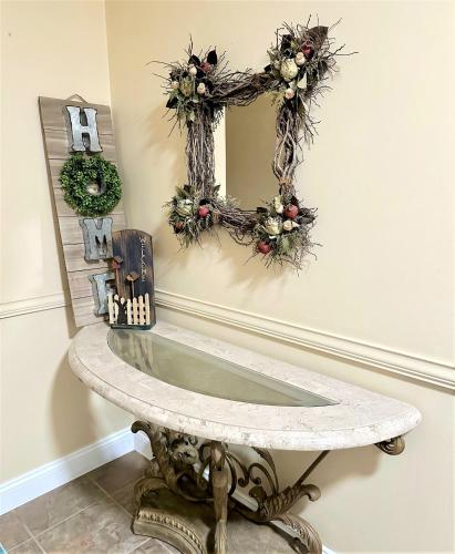 a console table with a mirror and christmas wreaths at WOW!! Ultimate Pocono Retreat, Hot Tub, Game Room, Deck, Lakes, Skiing, Pools in Long Pond