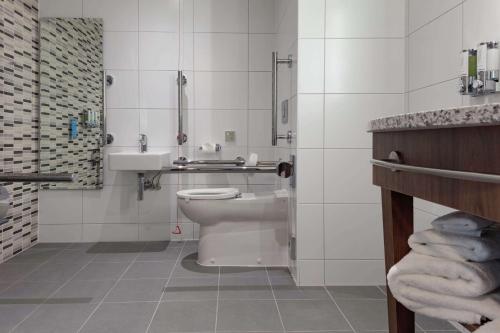 a bathroom with a toilet and a sink at Hampton By Hilton Edinburgh Airport in Ingliston