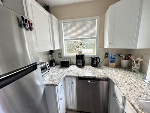 a kitchen with white cabinets and a granite counter top at WOW!! Ultimate Pocono Retreat, Hot Tub, Game Room, Deck, Lakes, Skiing, Pools in Long Pond