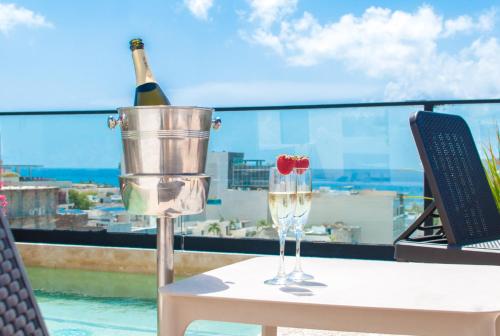 a bottle of wine and two glasses on a table at Kuxtal 3 Bedroom Downtown Apartment by Casago in Playa del Carmen