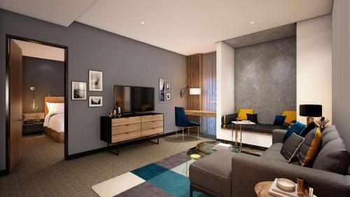 een woonkamer met een bank, een tv en een bed bij Hilton Woking in Woking