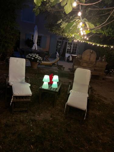 twee stoelen en een tafel met verlichting erop bij Le Mas de Trévouse in Saint-Saturnin-lès-Avignon