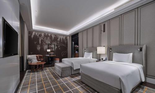 a hotel room with two beds and a television at Hilton Beijing Daxing in Beijing