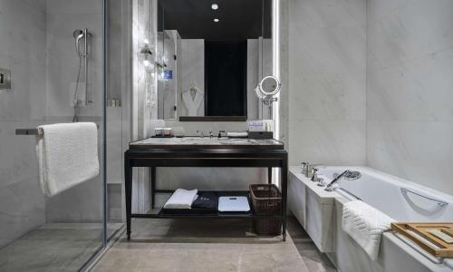 a bathroom with a tub and a sink and a bath tub at Hilton Beijing Daxing in Beijing