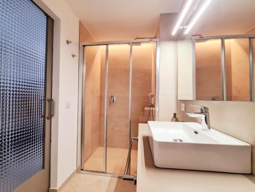 een badkamer met een wastafel en een douche bij Waki Conscious Hotel in Ciutadella