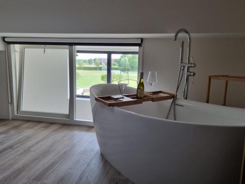 bañera blanca en una habitación con ventana en DW Castricum en Castricum
