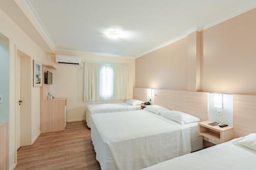 una camera d'albergo con due letti e una finestra di Bristol Sabrina Hotel de Charme Joinville a Joinville