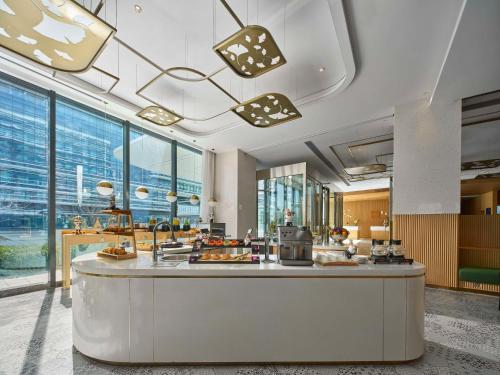 eine Hotellobby mit einer Theke mit Essen darauf in der Unterkunft Hilton Garden Inn Beijing Daxing International Airport in Peking