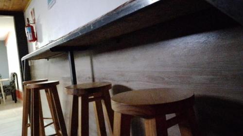 a couple of stools sitting next to a bar at Hostel Huellas Patagonicas in Junín de los Andes