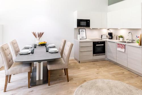a kitchen with a table and chairs in a room at Seaside Deluxe Loft - Beach, Free Parking & 10 min to Metro in Espoo