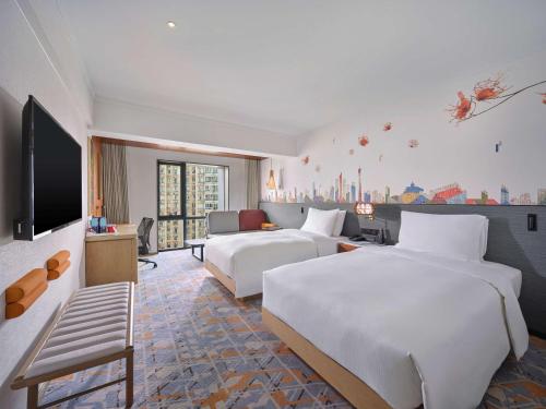広州市にあるHilton Garden Inn Guangzhou Tianheのベッド2台と薄型テレビ付きのホテルの部屋