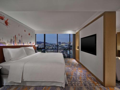 a bedroom with a large bed and a flat screen tv at Hilton Garden Inn Guangzhou Tianhe-Free Shuttle Bus and Buyer Registration Available during Canton Fair Period in Guangzhou