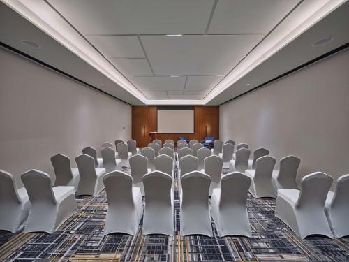 a conference room with chairs and a projection screen at Hilton Garden Inn Guangzhou Tianhe-Free Shuttle Bus and Buyer Registration Available during Canton Fair Period in Guangzhou