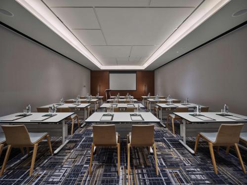 an empty room with tables and chairs and a whiteboard at Hilton Garden Inn Guangzhou Tianhe-Free Shuttle Bus and Buyer Registration Available during Canton Fair Period in Guangzhou