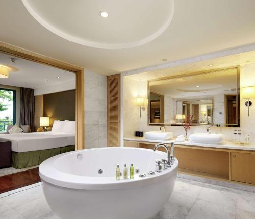 廣州的住宿－广州翡翠希尔顿酒店 - 免费穿梭巴士到广交会，大型浴室设有两个盥洗盆和浴缸。