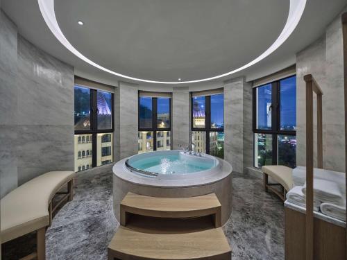 Doubletree By Hilton Yingde Resort في Yingde: حمام مع حوض كبير مع نوافذ
