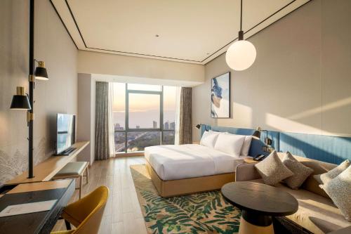 una camera d'albergo con letto e divano di Hilton Garden Inn Changde Dingcheng a Changde