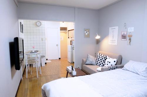 a bedroom with a bed and a couch and a table at Daiichi Mitsumi Corporation - Vacation STAY 14790 in Musashino