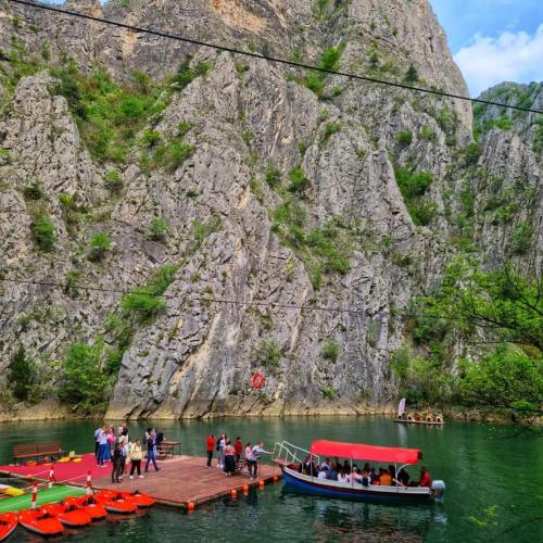 a group of people on a dock with boats in the water at Mona Apartments in Skopje