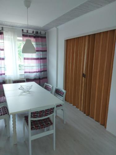 a dining room with a white table and chairs at Mona Apartments in Skopje
