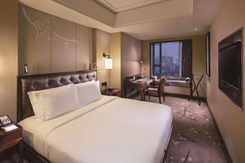 um quarto de hotel com uma cama grande e uma secretária em DoubleTree by Hilton Chongqing North em Chongqing