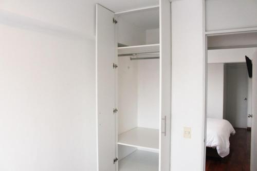 a white closet with a door open to a bedroom at DEPARTAMENTO con VISTA AL MAR in Lima