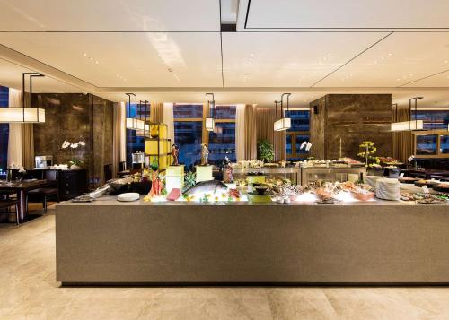 a lobby with a counter with food on it at DoubleTree by Hilton Chongqing - Nan'an in Chongqing