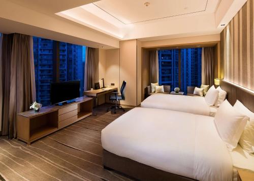ein Hotelzimmer mit 2 Betten und einem TV in der Unterkunft DoubleTree by Hilton Chongqing - Nan'an in Chongqing