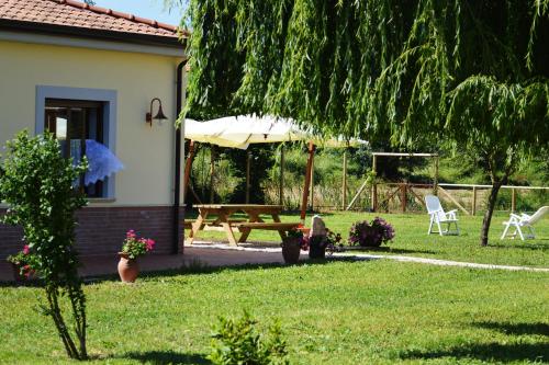 a house with a picnic table and chairs in the yard at Agriturismo Terra Di Elea azienda agricola di Raimondo MIchela in Ascea