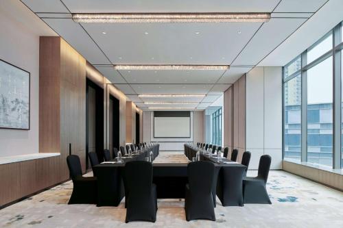a conference room with a long table and chairs at Hilton Changsha Riverside in Changsha