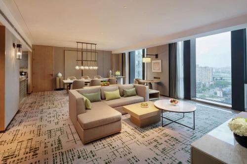 uma sala de estar com um sofá e uma mesa em Hilton Chengdu Chenghua em Chengdu