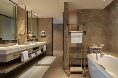 uma casa de banho com uma banheira e um lavatório e uma banheira em Hilton Chengdu Chenghua em Chengdu