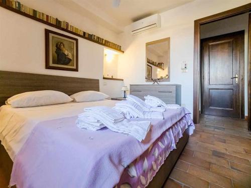1 dormitorio con 1 cama grande con sábanas blancas en La Casina di Rosi vivere nellantico borgo en Castiglione della Pescaia