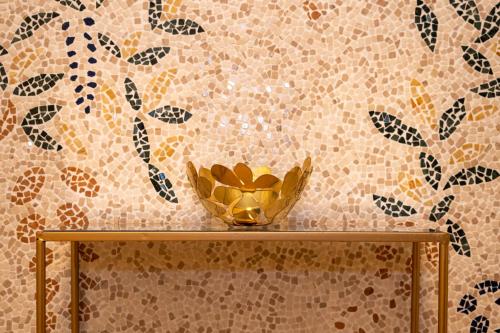 una ciotola d'oro su un tavolo davanti a un muro di Home Sicilia24 a Catania