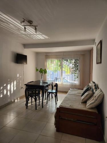 1 dormitorio con cama, mesa y ventana en Casa Tres Cerritos en Salta