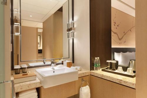 een badkamer met een wastafel en een spiegel bij Hilton Garden Inn Dandong in Dandong