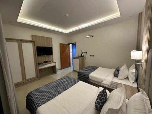 a hotel room with two beds and a television at قولد تاور in Khamis Mushayt