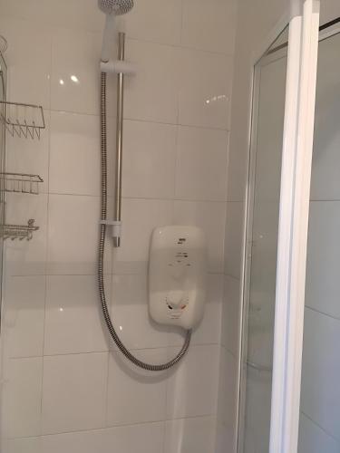a shower in a white bathroom with a shower at Logie Green - beautiful and central one bed flat in Edinburgh
