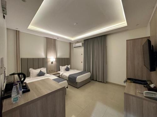 een hotelkamer met een bed en een bank bij قولد تاور in Khamis Mushayt