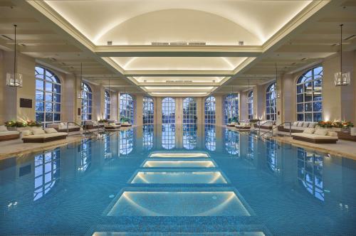 a swimming pool in a building with windows at Hilton Dalian Golden Pebble Beach Resort in Jinzhou