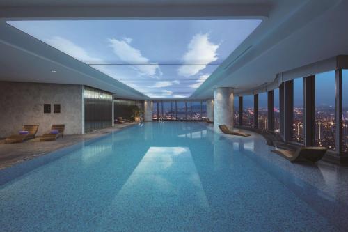 a swimming pool in a building with a view of the city at Hilton Fuzhou in Fuzhou