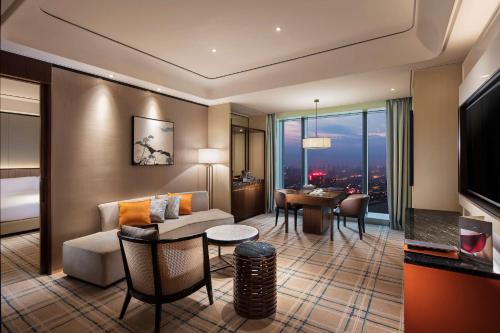 a living room with a couch and a dining room at Hilton Fuzhou in Fuzhou