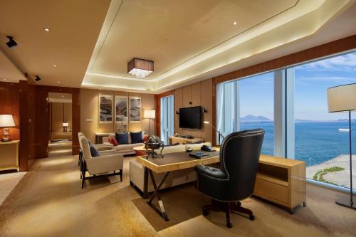 a hotel room with a desk and a room with a view at Hilton Dalian in Dalian