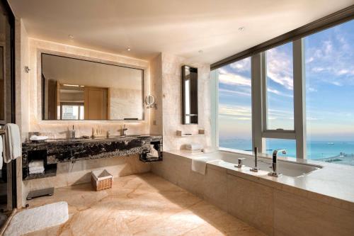 a bathroom with two sinks and a large window at Hilton Dalian in Dalian