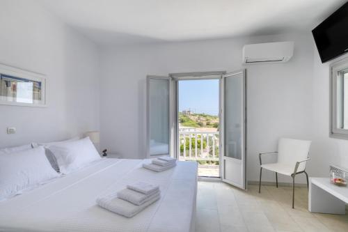 een witte slaapkamer met een wit bed en een balkon bij Villa Dioni in Santa Maria