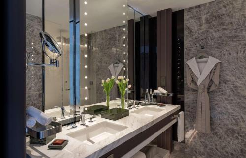 a bathroom with a sink and a large mirror at Conrad Hangzhou in Hangzhou