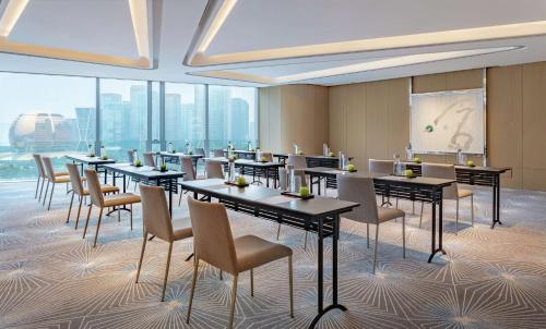 a conference room with tables and chairs and windows at Conrad Hangzhou in Hangzhou